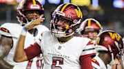 Sep 23, 2024; Cincinnati, Ohio, USA; Washington Commanders quarterback Jayden Daniels (5) reacts after scoring a touchdown against the Cincinnati Bengals in the first half at Paycor Stadium. Mandatory Credit: Katie Stratman-Imagn Images