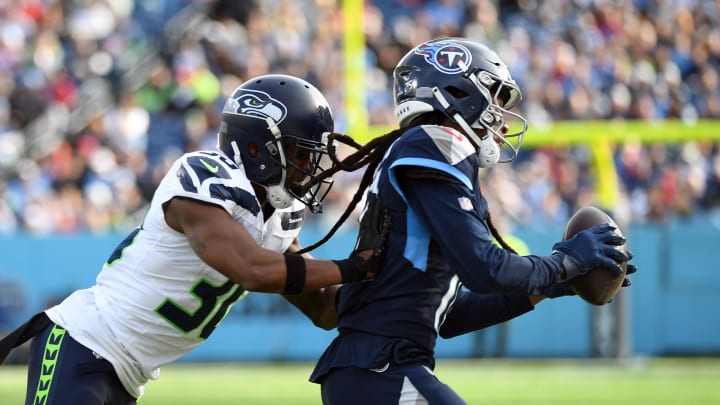 Dec 24, 2023; Nashville, Tennessee, USA; Tennessee Titans wide receiver DeAndre Hopkins (10) is pushed out of bounds by Seattle Seahawks cornerback Michael Jackson (30) after a catch during the first half at Nissan Stadium. Mandatory Credit: Christopher Hanewinckel-USA TODAY Sports