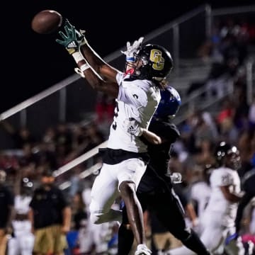Golden Gate Titans wide receiver Bradley Martino (2) makes a catch over Barron Collier Cougars defensive back Nathan Hendry (8) and scores a touchdown during the third quarter of a district game at Barron Collier High School in Naples on Friday, Oct. 13, 2023.