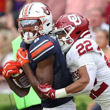 Auburn receiver Cam Coleman is tackled by Oklahoma safety Peyton Bowen.