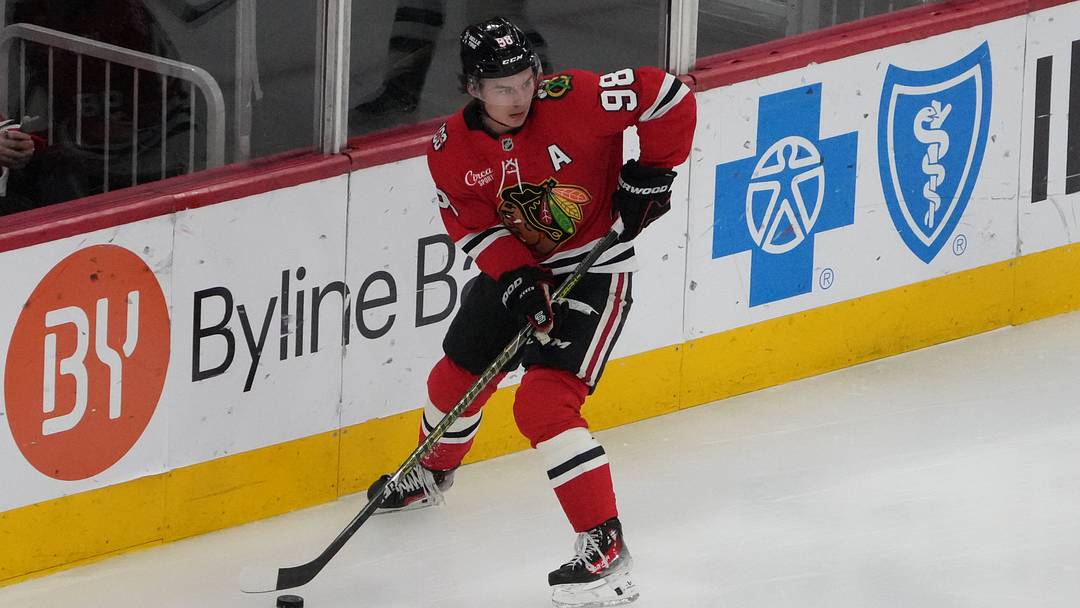 Apr 15, 2026; Chicago, Illinois, USA; Chicago Blackhawks center Connor Bedard (98) grabs the puck against the San Jose Sharks during the first period at United Center. Mandatory Credit: David Banks-Imagn Images