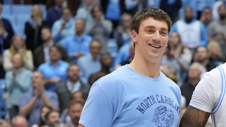 Jan 21, 2023; Chapel Hill, North Carolina, USA; Former North Carolina Tar Heels great Tyler Hansbrough presents forward Armando Bacot (5) with the game ball after the game. Bacot became the all-time Tar Heels rebounding leader during the game breaking Hansbrough   s record. Mandatory Credit: Bob Donnan-Imagn Images