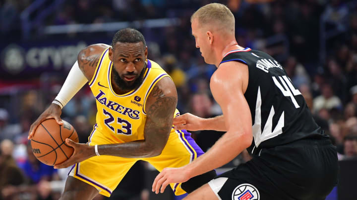 Feb 28, 2024; Los Angeles, California, USA; Los Angeles Lakers forward LeBron James (23) controls the ball against Los Angeles Clippers center Mason Plumlee (44) during the first half at Crypto.com Arena. Mandatory Credit: Gary A. Vasquez-USA TODAY Sports