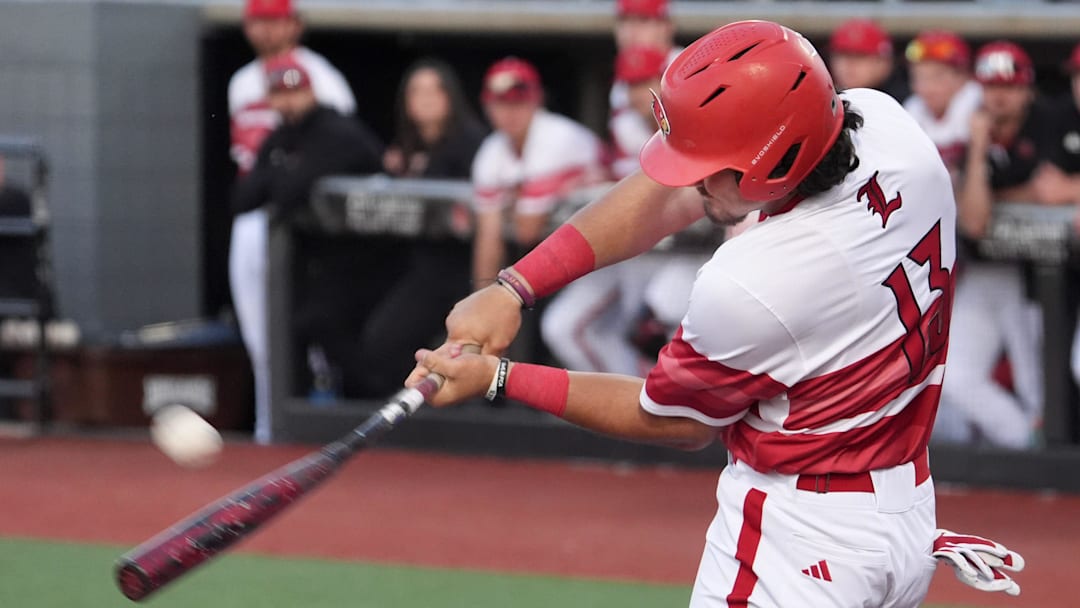 Louisville's Tague Davis (13) hits the ball to the fence for the out but enough time for Louisville's Jake Munroe (20) to tag up and head home against Vanderbilt Tuesday night at Jim Patterson Stadium.
May 6, 2025