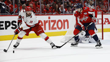 May 15, 2025; Washington, District of Columbia, USA; Carolina Hurricanes left wing William Carrier (28) passes the puck as Washington Capitals defenseman Trevor van Riemsdyk (57) defends in the second period in game five of the second round of the 2025 Stanley Cup Playoffs at Capital One Arena. Mandatory Credit: Geoff Burke-Imagn Images