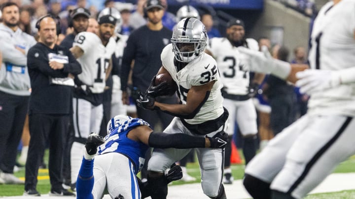Dec 31, 2023; Indianapolis, Indiana, USA; Las Vegas Raiders running back Zamir White (35) runs the ball while Indianapolis Colts linebacker E.J. Speed (45) defends  in the first quarter at Lucas Oil Stadium. Mandatory Credit: Trevor Ruszkowski-USA TODAY Sports