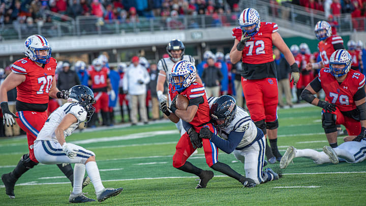 Cherry Creek running back Jordan Herron battles through a Columbine tackler during the Colorado 5A football state championship on Saturday, Dec. 2, 2023 at Canvas Stadium in Fort Collins, Colo.