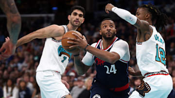 Dec 23, 2024; Memphis, Tennessee, USA; Los Angeles Clippers guard Norman Powell (24) drives to the basket between Memphis Grizzlies forward Santi Aldama (7) and guard Ja Morant (12) during the fourth quarter at FedExForum. Mandatory Credit: Petre Thomas-Imagn Images