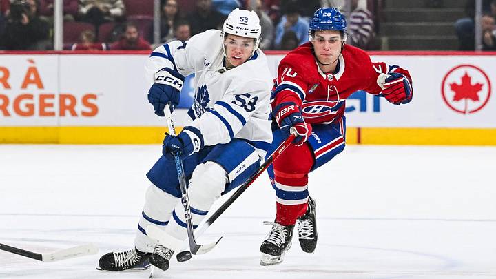 Sep 30, 2023; Montreal, Quebec, CAN; Toronto Maple Leafs right wing Easton Cowan (53) plays the puck against Montreal Canadiens left wing Juraj Slafkovsky (20) during the first period at Bell Centre. Mandatory Credit: David Kirouac-Imagn Images