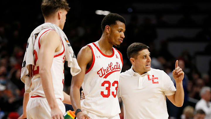 Cincinnati Bearcats forward Ody Oguama (33) talks with  head coach Wes Miller going into a timeout