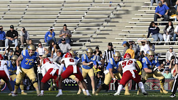 Nov 30, 2024; Pasadena, California, USA; UCLA Bruins quarterback Ethan Garbers takes the snap against the Fresno State Bulldogs during the fourth quarter at Rose Bowl. It was a sparse crowd for the game on a holiday weekend. Mandatory Credit: Robert Hanashiro-Imagn Images