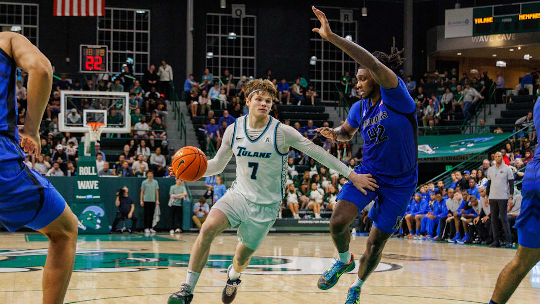 Jan 30, 2025; New Orleans, Louisiana, USA; Tulane Green Wave guard Rowan Brumbaugh (7) drives to the basket against Memphis Tigers forward Dain Dainja (42) during the second half at Avron B. Fogelman Arena in Devlin Fieldhouse. 