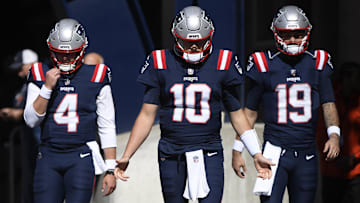 Oct 8, 2023; Foxborough, Massachusetts, USA; New England Patriots quarterback Bailey Zappe (4) quarterback Mac Jones (10) and quarterback Will Grier (19) walk out of the tunnel prior to a game against the New Orleans Saints at Gillette Stadium. Mandatory Credit: Bob DeChiara-Imagn Images