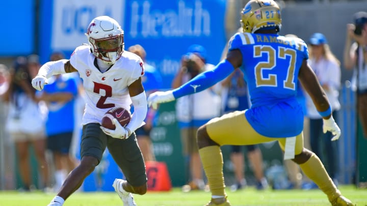 Oct 7, 2023; Pasadena, California, USA; Washington State Cougars wide receiver Kyle Williams (2) runs the ball against UCLA Bruins defensive back Kamari Ramsey (27) during the second half at Rose Bowl. Mandatory Credit: Gary A. Vasquez-USA TODAY Sports