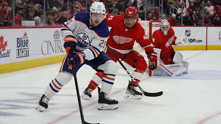 Jan 11, 2024; Detroit, Michigan, USA;  Edmonton Oilers left wing Adam Erne (21) skates with the puck chased by Detroit Red Wings defenseman Shayne Gostisbehere (41) in the third period at Little Caesars Arena. Mandatory Credit: Rick Osentoski-Imagn Images