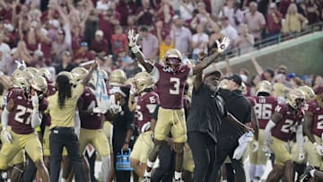 Florida State Seminoles running back Kam Davis and associate head coach Odell Haggins react after beating Alabama 