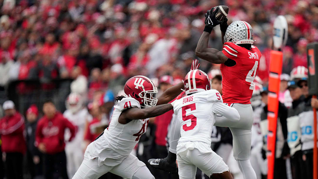 Ohio State Buckeyes wide receiver Jeremiah Smith (4) makes a catch against Indiana Hoosiers defensive lineman Lanell Carr Jr. (41) and defensive back D'Angelo Ponds (5) in the third quarter during the football game in Columbus on Saturday, Nov. 23, 2024.
