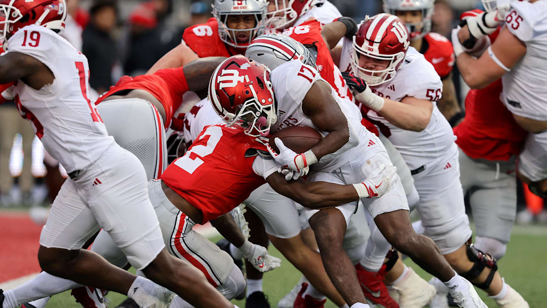 Nov 23, 2024; Columbus, Ohio, USA;  Indiana Hoosiers running back Ty Son Lawton (17) runs the ball as Ohio State Buckeyes safety Caleb Downs (2) comes up to make the tackle during the fourth quarter at Ohio Stadium. Mandatory Credit: Joseph Maiorana-Imagn Images
