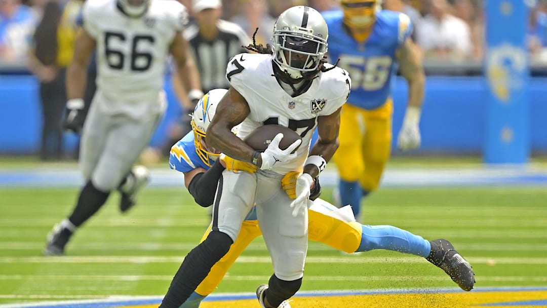 Sep 8, 2024; Inglewood, California, USA; Las Vegas Raiders wide receiver Davante Adams (17) is stopped by Los Angeles Chargers safety Alohi Gilman (32) after a compete pass in the first half at SoFi Stadium. Mandatory Credit: Jayne Kamin-Oncea-Imagn Images