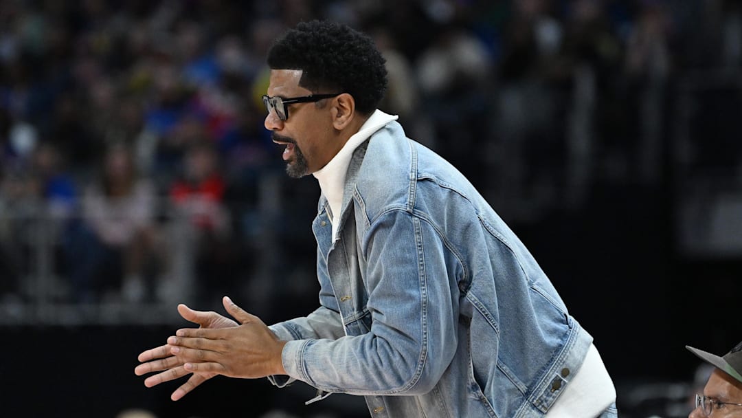 Nov 10, 2024; Detroit, Michigan, USA;  Former NBA player and Detroit native, Jalen Rose, cheers on the Detroit Pistons from his court side seat during their game against the Houston Rockets in the second quarter at Little Caesars Arena. Mandatory Credit: Lon Horwedel-Imagn Images