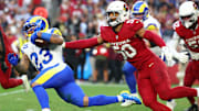 Dec 7, 2025; Glendale, Arizona, USA; Los Angeles Rams running back Kyren Williams (23) rushes the ball past Arizona Cardinals linebacker Cody Simon (50) during the second half at State Farm Stadium. Mandatory Credit: Mark J. Rebilas-Imagn Images