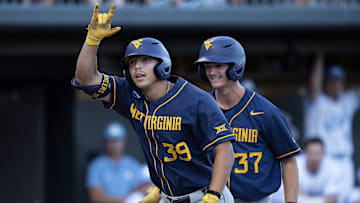 Jun 7, 2024; Chapel Hill, NC, USA; West Virginia Mountaineers Kyle West (39) motions to the dugout in front of teammate Grant Siegel (37) in the fifth inning of the DI Baseball Super Regional against the North Carolina Tar Heels at Boshamer Stadium.  Mandatory Credit: Jeffrey Camarati-Imagn Images