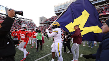 Nov 30, 2024; Columbus, Ohio, USA;  Michigan Wolverines defensive end Derrick Moore (8) attempts to plant the flag on the Ohio State Buckeyes logo as Ohio State Buckeyes defensive end Jack Sawyer (33) rips the flag down after the game at Ohio Stadium. Mandatory Credit: Joseph Maiorana-Imagn Images