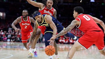 Feb 16, 2025; Columbus, Ohio, USA;  Michigan Wolverines guard Roddy Gayle Jr. (11) loses the ball as Ohio State Buckeyes forward Devin Royal (21) and Ohio State Buckeyes guard John Mobley Jr. (0) defend during the first half at Value City Arena. Mandatory Credit: Joseph Maiorana-Imagn Images
