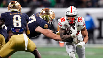 Ohio State Buckeyes running back TreVeyon Henderson (32) carries the ball on a run against Notre Dame Fighting Irish defensive lineman Gabriel Rubio (97) in the third quarter during the College Football Playoff championship at Mercedes-Benz Stadium in Atlanta on January 20, 2025.
