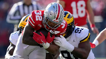 Ohio State Buckeyes running back TreVeyon Henderson (32) gets tackled by Michigan Wolverines defensive end Cameron Brandt (91) during the first quarter of the NCAA football game at Ohio Stadium in Columbus on Saturday, Nov. 30, 2024.