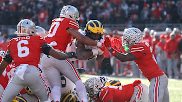 Nov 30, 2024; Columbus, Ohio, USA;  Michigan Wolverines running back Kalel Mullings (20) dives for the first down as Ohio State Buckeyes linebacker Cody Simon (0) and safety Caleb Downs(2) make the stop during the second half at Ohio Stadium. Mandatory Credit: Joseph Maiorana-Imagn Images