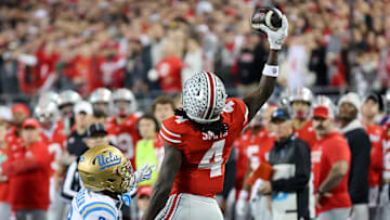 Nov 15, 2025; Columbus, Ohio, USA;  Ohio State Buckeyes wide receiver Jeremiah Smith (4) makes a one handed first down catch as UCLA Bruins defensive back Andre Jordan Jr. (2) defends during the first quarter at Ohio Stadium. Mandatory Credit: Joseph Maiorana-Imagn Images