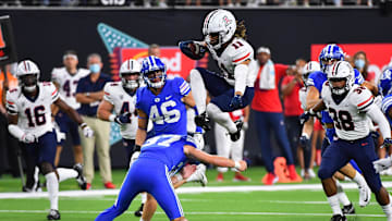 Sep 4, 2021; Paradise, Nevada, USA; Arizona Wildcats wide receiver Tayvian Cunningham (11) hurdles Brigham Young Cougars place kicker Justen Smith (37) on a return during a game at Allegiant Stadium. Mandatory Credit: Stephen R. Sylvanie-Imagn Images