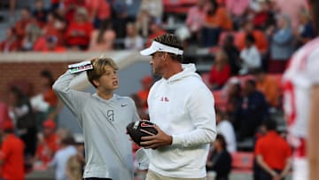 Oct 21, 2023; Auburn, Alabama, USA;  Mississippi Rebels head coach Lane Kiffin (right) talks with his son Knox before a game against the Auburn Tigers at Jordan-Hare Stadium. Mandatory Credit: John Reed-Imagn Images