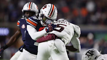 Nov 23, 2024; Auburn, Alabama, USA;  Texas A&M Aggies running back Amari Daniels (5) is tackled by Auburn Tigers safety Kaleb Harris (18) during the second quarter at Jordan-Hare Stadium. Mandatory Credit: John Reed-Imagn Images