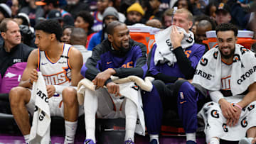 Jan 16, 2025; Washington, District of Columbia, USA; Phoenix Suns forward Kevin Durant (35) reacts on the bench with center Mason Plumlee (22), and guard Tyus Jones (21) during the fourth quarter against the Washington Wizards at Capital One Arena. Mandatory Credit: Reggie Hildred-Imagn Images
