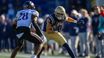 Nov 18, 2023; Annapolis, Maryland, USA; Navy Midshipmen wide receiver Regis Velez (84) runs the ball against East Carolina Pirates defensive back Shavon Revel (28) during the second quarter at Navy-Marine Corps Memorial Stadium. Mandatory Credit: Reggie Hildred-Imagn Images