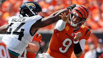Sep 14, 2025; Cincinnati, Ohio, USA;  Cincinnati Bengals quarterback Joe Burrow (9) takes a hit to the head from Jacksonville Jaguars defensive end Travon Walker (44) during the first quarter at Paycor Stadium. Mandatory Credit: Joseph Maiorana-Imagn Images