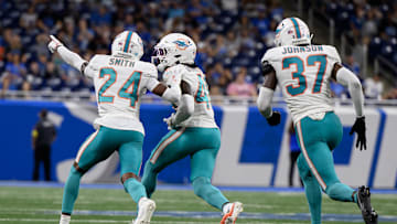 Aug 16, 2025; Detroit, Michigan, USA; Miami Dolphins cornerback Ethan Robinson (46) celebrates with teammates Cam Smith (24) and Isaiah Johnson (37) after intercepting a pass against the Detroit Lions in the fourth quarter at Ford Field. Mandatory Credit: Lon Horwedel-Imagn Images