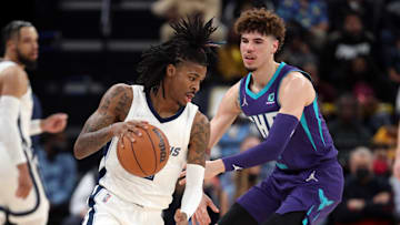 Nov 10, 2021; Memphis, Tennessee, USA; Memphis Grizzles guard Ja Morant (12) dribbles as Charlotte Hornets guard LaMelo Ball (2) defends during the first half at FedExForum. Mandatory Credit: Petre Thomas-Imagn Images