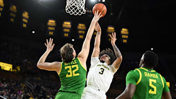 Feb 5, 2025; Ann Arbor, Michigan, USA;  Michigan Wolverines guard Tre Donaldson (3) puts up a shot over Oregon Ducks center Nate Bittle (32) in the first half at Crisler Center. Mandatory Credit: Lon Horwedel-Imagn Images