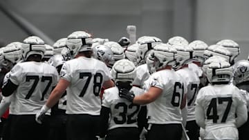 Jul 31, 2023; Henderson, NV, USA; Las Vegas Raiders wearing Guardian helmet caps huddle during training camp at the Intermountain Health Performance Center. Mandatory Credit: Kirby Lee-Imagn Images