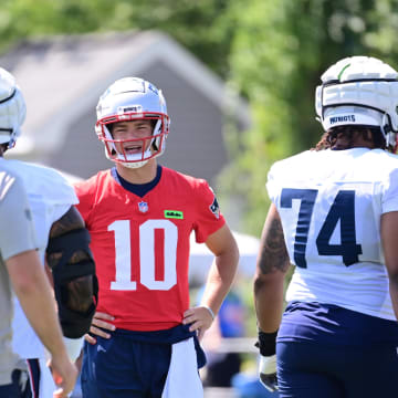 Jul 26, 2024; Foxborough, MA, USA; New England Patriots quarterback Drake Maye (10) talks to coaching staff members between snaps during training camp at Gillette Stadium. Mandatory Credit: Eric Canha-USA TODAY Sports