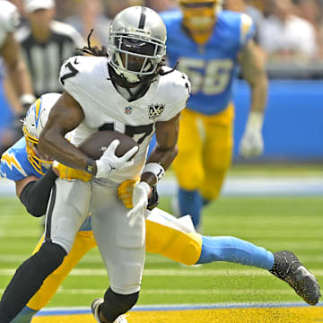 Sep 8, 2024; Inglewood, California, USA; Las Vegas Raiders wide receiver Davante Adams (17) is stopped by Los Angeles Chargers safety Alohi Gilman (32) after a compete pass in the first half at SoFi Stadium. Mandatory Credit: Jayne Kamin-Oncea-Imagn Images