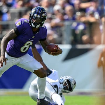 Baltimore Ravens quarterback Lamar Jackson (8) leaps over Las Vegas Raiders cornerback Jakorian Bennett (0) during the first half at M&T Bank Stadium. 