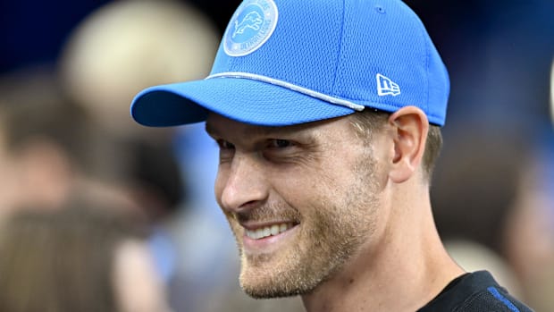 Detroit Lions offensive coordinator Ben Johnson talks with fans on the sidelines 