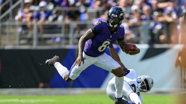 Baltimore Ravens quarterback Lamar Jackson (8) leaps over Las Vegas Raiders cornerback Jakorian Bennett (0