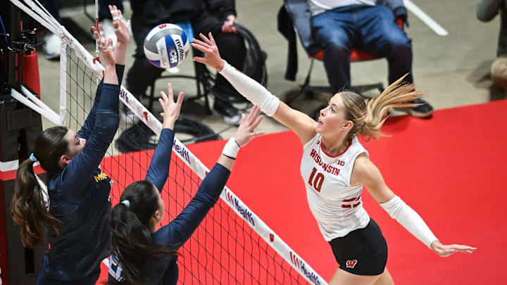 Wisconsin outside hitter Madison Quest (10) directs the ball around the Marquette block in a spring match Wednesday, April 16, 2025, at the UW Field House in Madison, Wisconsin.