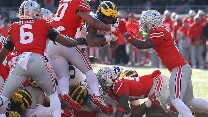 Nov 30, 2024; Columbus, Ohio, USA;  Michigan Wolverines running back Kalel Mullings (20) dives for the first down as Ohio State Buckeyes linebacker Cody Simon (0) and safety Caleb Downs(2) make the stop during the second half at Ohio Stadium. Mandatory Credit: Joseph Maiorana-Imagn Images