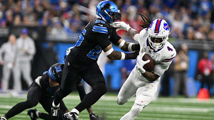Dec 15, 2024; Detroit, Michigan, USA; Buffalo Bills running back James Cook (4) breaks a tackle by Detroit Lions cornerback Kindle Vildor (29) and safety Kerby Joseph (31) before running for a touchdown in the third quarter at Ford Field. Mandatory Credit: Lon Horwedel-Imagn Images